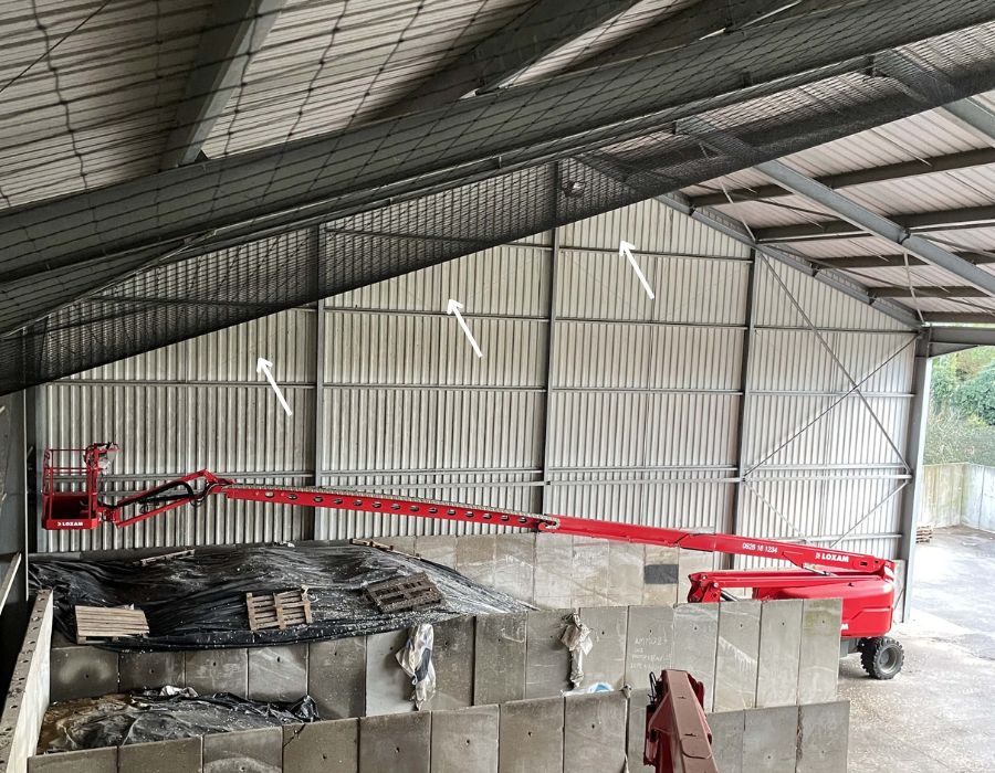 filet anti pigeons posé dans grand hangar avec grue rouge